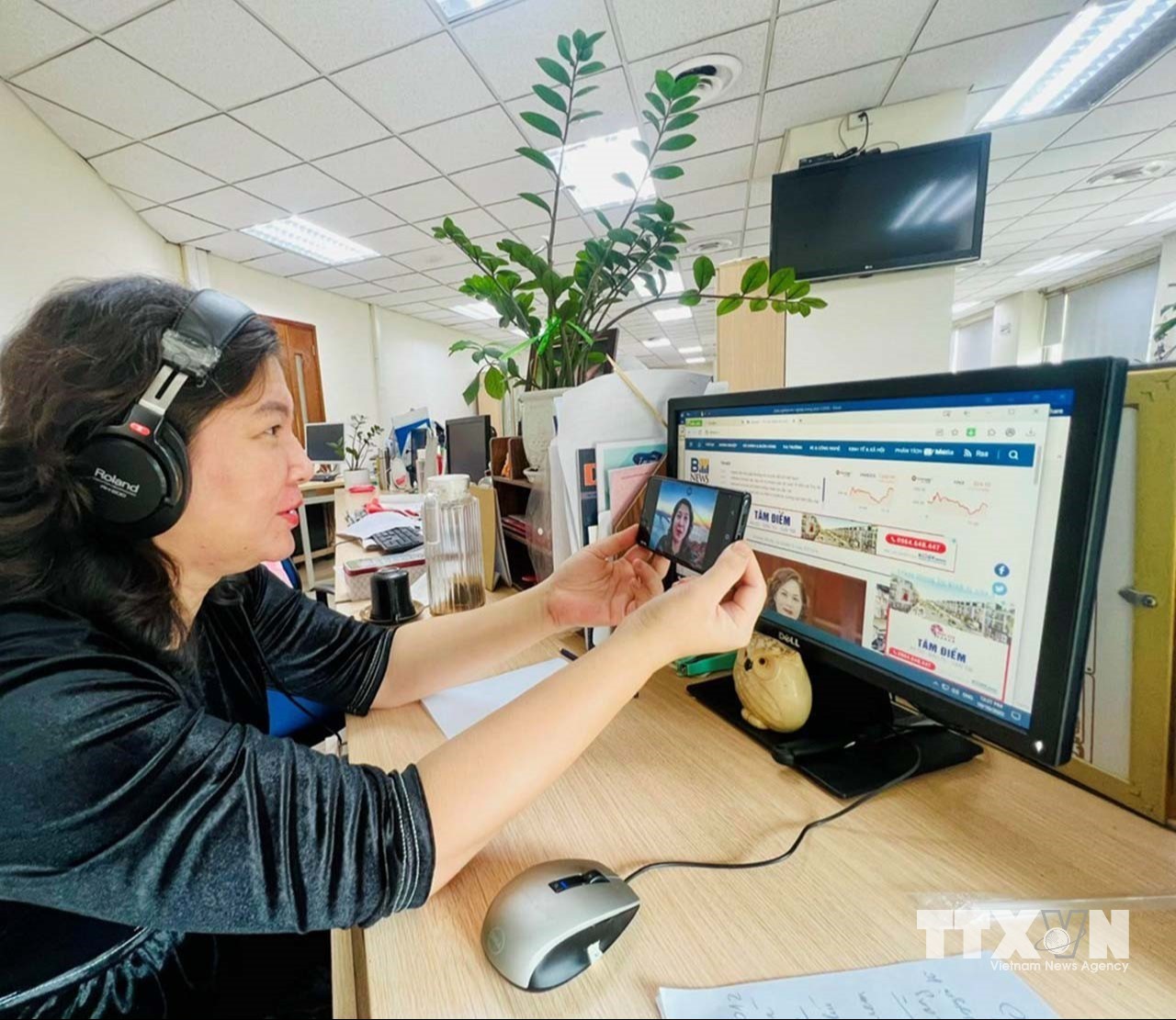 Phóng viên Kim Anh phỏng vấn trực tuyến qua ứng dụng Zoom để thu thập thông tin cho các bài viết, bản tin truyền hình. (Ảnh: TTXVN)